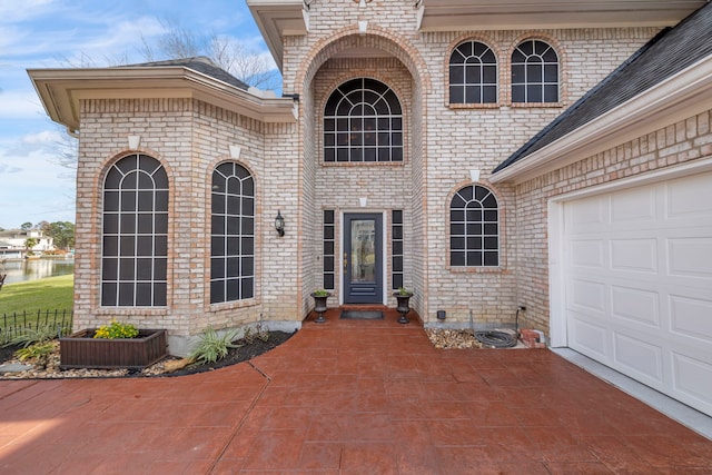 44 Logansport Ct, Montgomery, TX 77356 - doorway to property featuring brick siding, a garage, and driveway