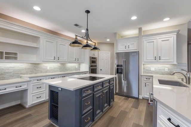 44 Logansport Ct, Montgomery, TX 77356 - kitchen with stainless steel appliances, a sink, blue cabinets, white cabinetry, and open shelves
