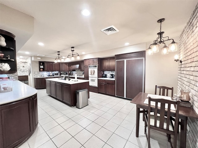 2016 Main St Unit Ph3, Houston, TX 77002 - kitchen with paneled built in fridge, white double oven, light countertops, decorative backsplash, and recessed lighting