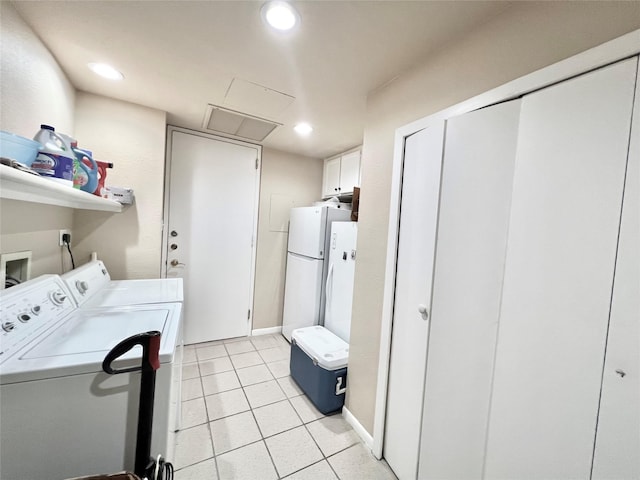 2016 Main St Unit Ph3, Houston, TX 77002 - laundry room featuring washing machine and clothes dryer, recessed lighting, light tile patterned flooring, and cabinet space