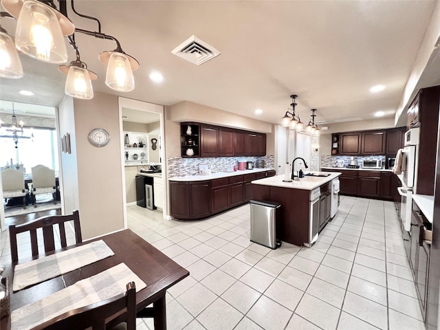 2016 Main St Unit Ph3, Houston, TX 77002 - kitchen featuring a sink, decorative backsplash, a center island with sink, dark brown cabinetry, and recessed lighting