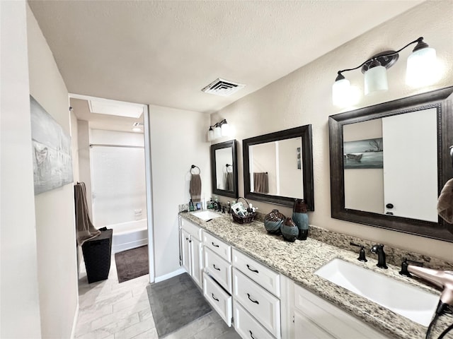 2016 Main St Unit Ph3, Houston, TX 77002 - bathroom featuring double vanity,  shower combination, and a textured ceiling