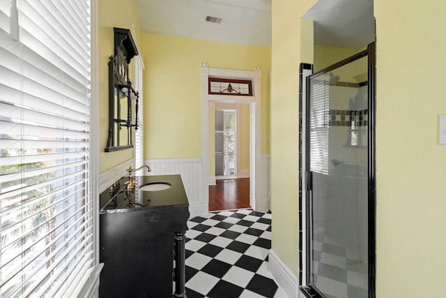 1827 Ball St, Galveston, TX 77550 - bathroom featuring tile patterned floors, wainscoting, vanity, and a shower stall