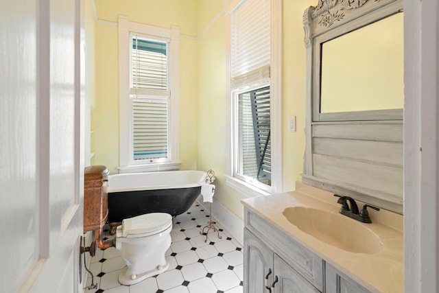 1827 Ball St, Galveston, TX 77550 - full bathroom with a soaking tub, tile patterned floors, vanity, toilet, and baseboards