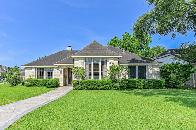 4734 Baywood Dr, Pasadena, TX 77505 - view of front of house featuring a front yard, a shingled roof, a chimney, and stone siding