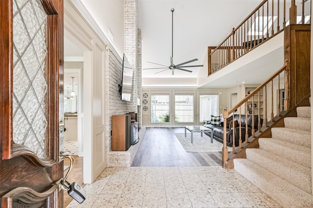4734 Baywood Dr, Pasadena, TX 77505 - entrance foyer featuring a high ceiling, ceiling fan, stairway, a brick fireplace, and wood finished floors