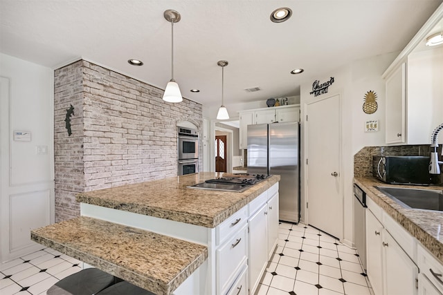 4734 Baywood Dr, Pasadena, TX 77505 - kitchen with appliances with stainless steel finishes, brick wall, white cabinets, light floors, and light countertops