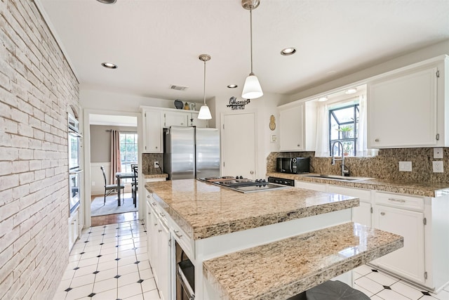 4734 Baywood Dr, Pasadena, TX 77505 - kitchen with a sink, stainless steel appliances, a kitchen island, white cabinetry, and recessed lighting