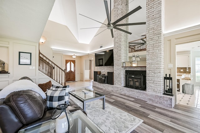 4734 Baywood Dr, Pasadena, TX 77505 - living area featuring a ceiling fan, stairway, wood finished floors, a brick fireplace, and a high ceiling