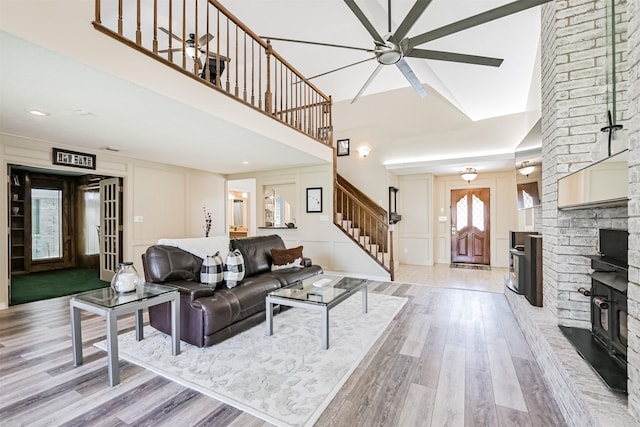 4734 Baywood Dr, Pasadena, TX 77505 - living area featuring a decorative wall, light wood-style floors, stairs, ceiling fan, and a fireplace