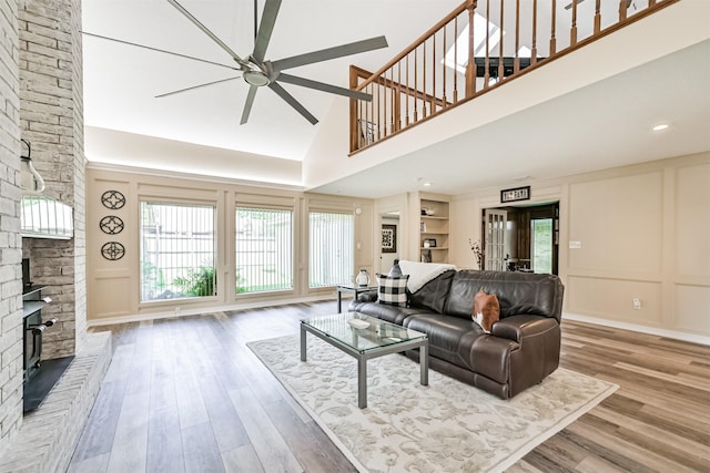 4734 Baywood Dr, Pasadena, TX 77505 - living room featuring a fireplace, a ceiling fan, wood finished floors, a decorative wall, and healthy amount of natural light