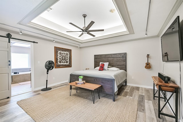 4734 Baywood Dr, Pasadena, TX 77505 - bedroom featuring a raised ceiling, light wood-type flooring, baseboards, ensuite bath, and ceiling fan