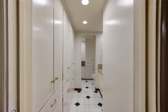 hall featuring recessed lighting, light tile patterned floors, and baseboards