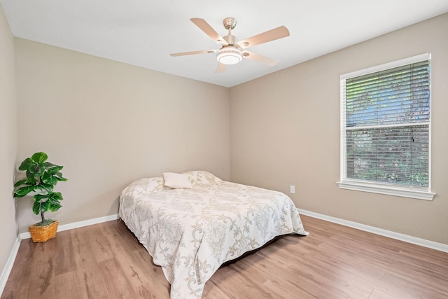 6719 Woodland Oaks, Magnolia, TX 77354 - bedroom with light wood finished floors, baseboards, and ceiling fan