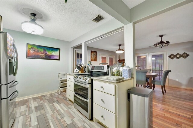7027 Iowa Colony Blvd, Rosharon, TX 77583 - kitchen with appliances with stainless steel finishes, ceiling fan, white cabinetry, light wood-type flooring, and baseboards
