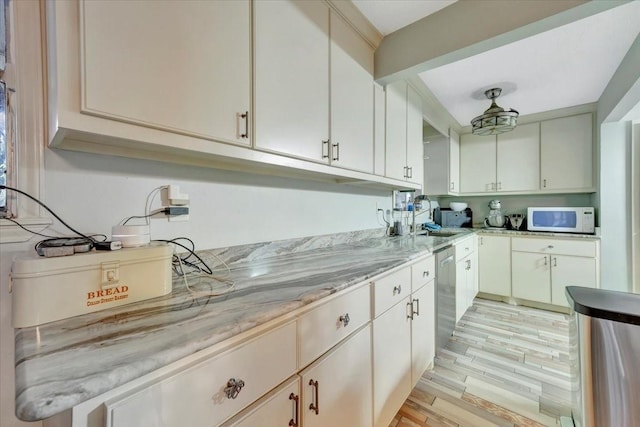 7027 Iowa Colony Blvd, Rosharon, TX 77583 - kitchen featuring white microwave, dishwasher, a sink, light stone counters, and light wood-type flooring