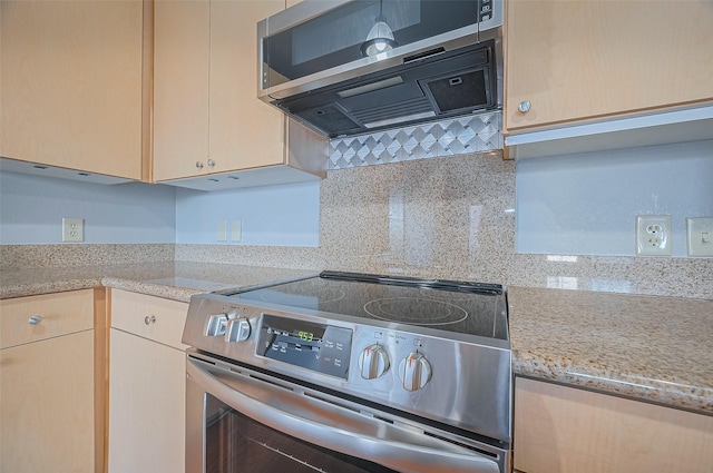 kitchen with appliances with stainless steel finishes, tasteful backsplash, light stone countertops, and exhaust hood