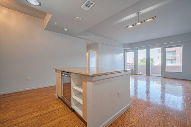 kitchen featuring a kitchen island, beverage cooler, open shelves, light wood-style flooring, and open floor plan