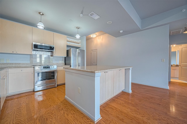 kitchen with stainless steel appliances, light wood-style floors, a center island, decorative backsplash, and pendant lighting