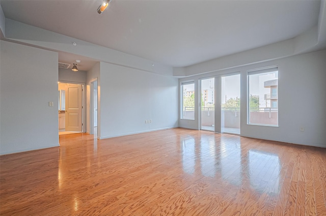 spare room featuring light wood-type flooring and baseboards
