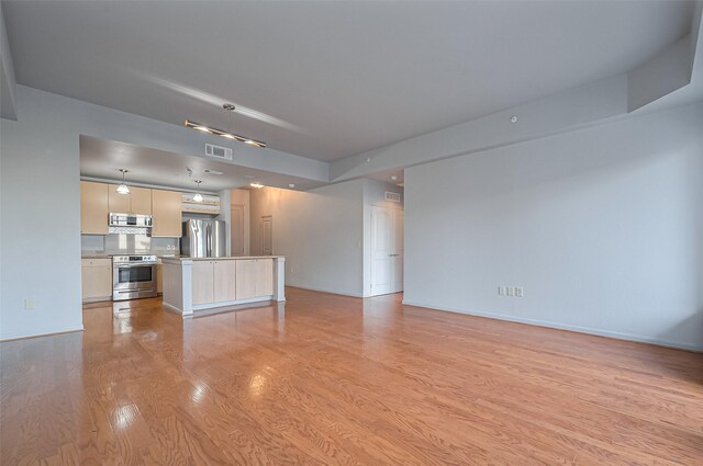 unfurnished living room with light wood-style flooring and baseboards