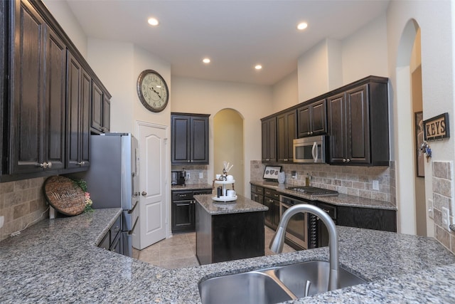 15623 Lavender Bay Ln, Cypress, TX 77429 - kitchen with appliances with stainless steel finishes, a sink, arched walkways, decorative backsplash, and recessed lighting