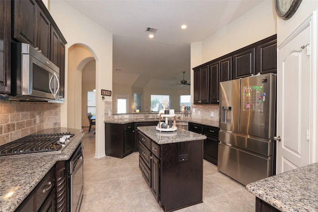 15623 Lavender Bay Ln, Cypress, TX 77429 - kitchen with stainless steel appliances, ceiling fan, backsplash, arched walkways, and a sink