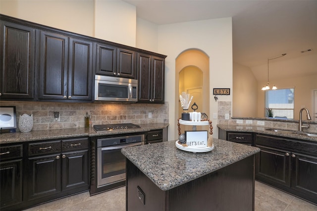 15623 Lavender Bay Ln, Cypress, TX 77429 - kitchen featuring appliances with stainless steel finishes, a sink, dark stone counters, decorative backsplash, and lofted ceiling