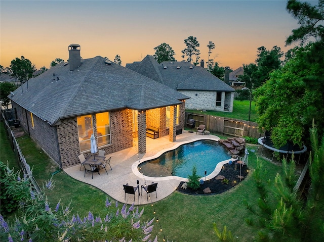 16711 Ramsay Cascades Dr, Humble, TX 77346 - back of house featuring brick siding, a shingled roof, a patio area, and a chimney