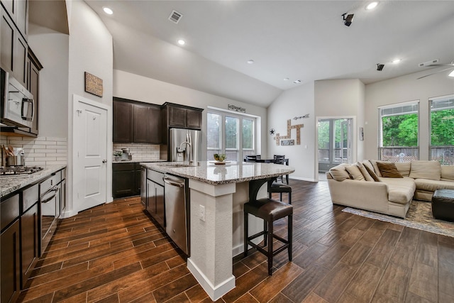 16711 Ramsay Cascades Dr, Humble, TX 77346 - kitchen featuring open floor plan, appliances with stainless steel finishes, dark wood-type flooring, a sink, and a breakfast bar area