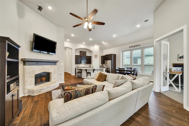 16711 Ramsay Cascades Dr, Humble, TX 77346 - living area with a ceiling fan, dark wood-style flooring, lofted ceiling, a fireplace, and arched walkways