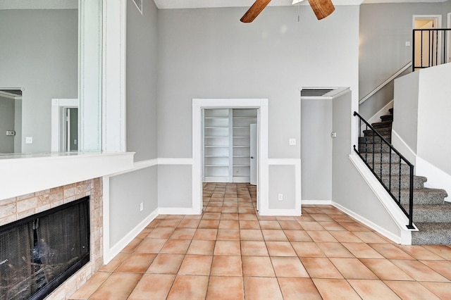 4319 Conward Dr, Houston, TX 77066 - unfurnished living room with a towering ceiling, ceiling fan, built in features, stairs, and baseboards