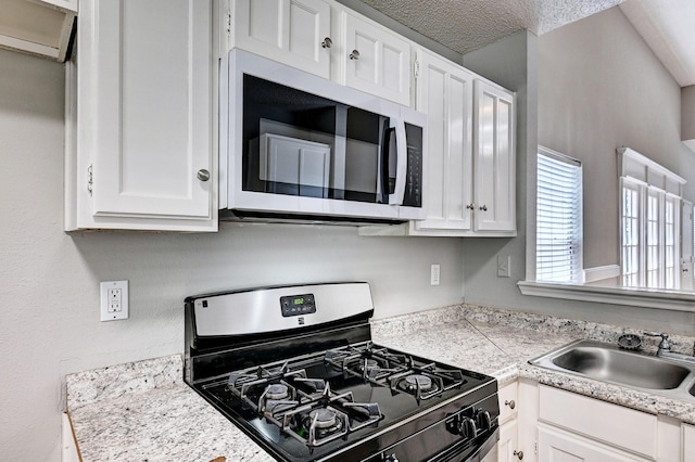 4319 Conward Dr, Houston, TX 77066 - kitchen featuring gas stove, light countertops, white cabinetry, and a sink