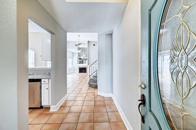 4319 Conward Dr, Houston, TX 77066 - entrance foyer featuring light tile patterned flooring, stairs, a ceiling fan, baseboards, and a textured ceiling