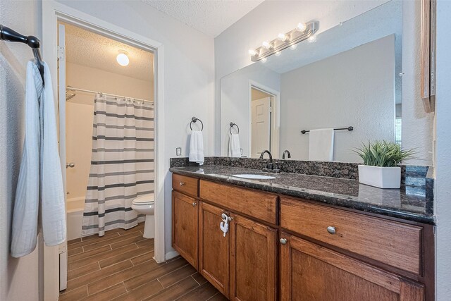 10315 Sun City Ct, Houston, TX 77099 - bathroom featuring wood finish floors, a textured ceiling, toilet, vanity, and shower / bath combination with curtain