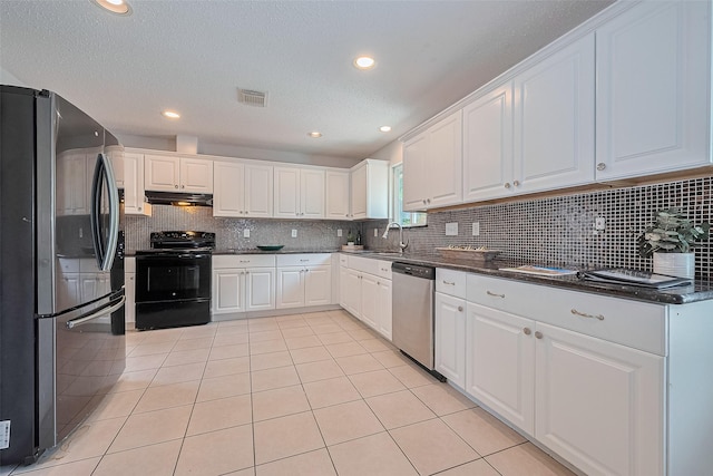 10315 Sun City Ct, Houston, TX 77099 - kitchen with stainless steel appliances, under cabinet range hood, decorative backsplash, white cabinets, and light tile patterned floors