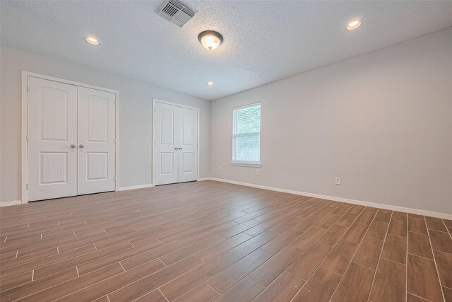 10315 Sun City Ct, Houston, TX 77099 - unfurnished bedroom with wood finished floors, a textured ceiling, baseboards, and recessed lighting
