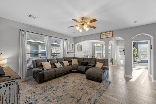 8315 Egret Bay Cir, Baytown, TX 77523 - living room with arched walkways, a ceiling fan, wood finished floors, baseboards, and a chandelier