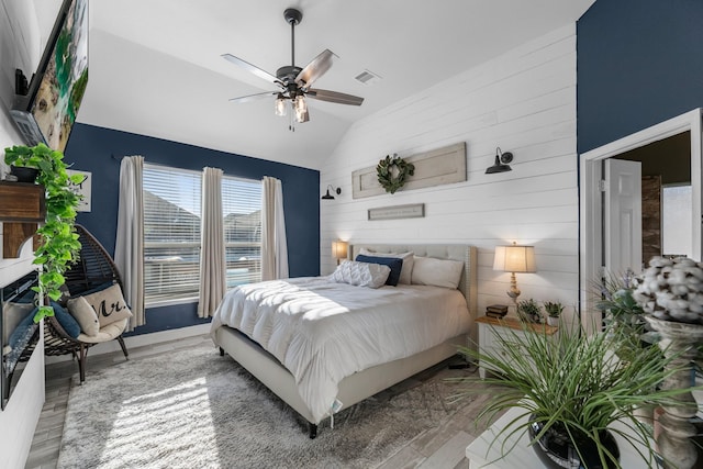 8315 Egret Bay Cir, Baytown, TX 77523 - bedroom featuring lofted ceiling, wood finished floors, wooden walls, and a ceiling fan