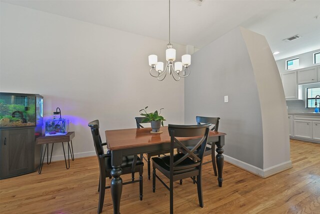8715 Meadowcroft Dr Unit 1002, Houston, TX 77063 - dining room featuring light wood finished floors, baseboards, and a chandelier