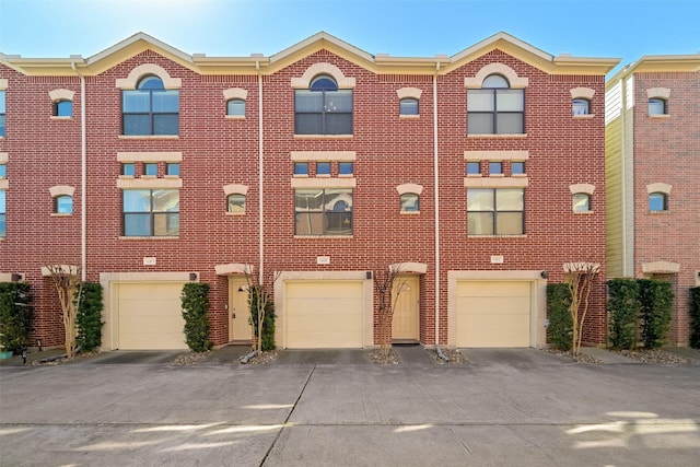 8715 Meadowcroft Dr Unit 1002, Houston, TX 77063 - view of front facade featuring brick siding, driveway, and a garage