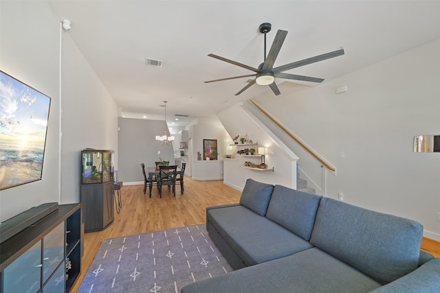 8715 Meadowcroft Dr Unit 1002, Houston, TX 77063 - living area with light wood-style flooring, stairs, a chandelier, a ceiling fan, and baseboards