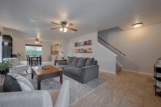 22627 Williamschase Dr, Katy, TX 77449 - living area with a ceiling fan, stairs, light tile patterned floors, baseboards, and a textured ceiling