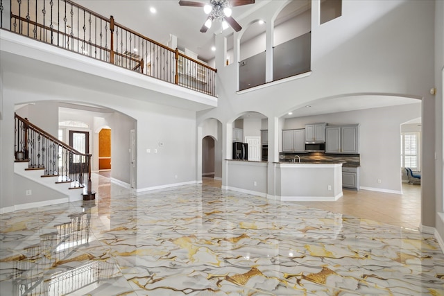 11127 Salento Ct, Richmond, TX 77406 - unfurnished living room with light marble finish flooring, a ceiling fan, a high ceiling, recessed lighting, and a sink