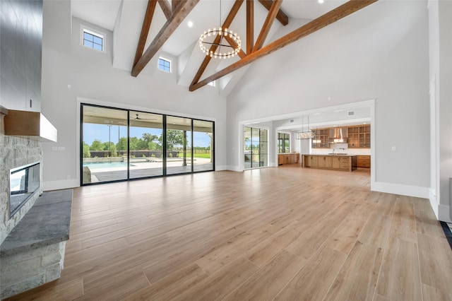 18829 Cypress Church Rd, Cypress, TX 77433 - unfurnished living room featuring high vaulted ceiling, a chandelier, a stone fireplace, beam ceiling, and baseboards