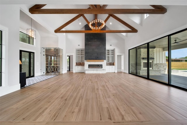 18829 Cypress Church Rd, Cypress, TX 77433 - unfurnished living room featuring a chandelier, high vaulted ceiling, beam ceiling, light wood-type flooring, and a fireplace
