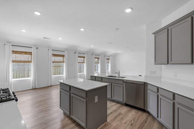 17723 Sapphire Pines Dr, New Caney, TX 77357 - kitchen with stainless steel dishwasher, gray cabinetry, a sink, recessed lighting, and a center island