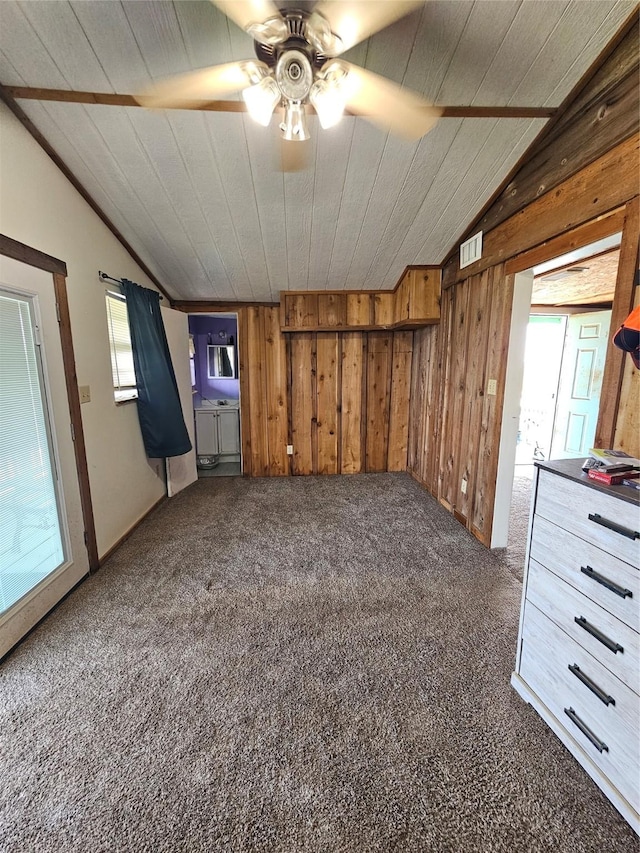 14545 Mariner St, Sargent, TX 77414 - unfurnished room with lofted ceiling, healthy amount of natural light, a ceiling fan, dark carpet, and wood walls