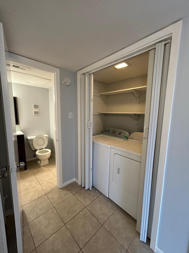 8435 Hearth Dr Unit 21, Houston, TX 77054 - laundry room with separate washer and dryer, light tile patterned flooring, and baseboards