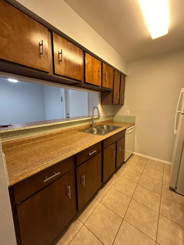 8435 Hearth Dr Unit 21, Houston, TX 77054 - kitchen featuring a sink, white appliances, light tile patterned floors, baseboards, and a textured ceiling
